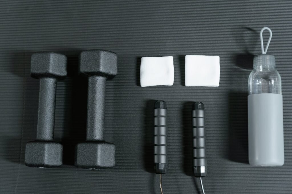 Flat lay of dumbbells, jump rope, and other gym essentials for a healthy lifestyle.